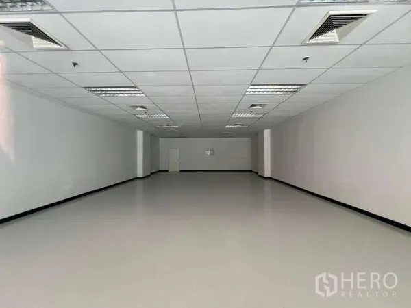 Retail Space for rent in Pathum Wan, Bangkok - Empty 116 sqm retail unit with white walls, suspended ceiling and fluorescent lighting.