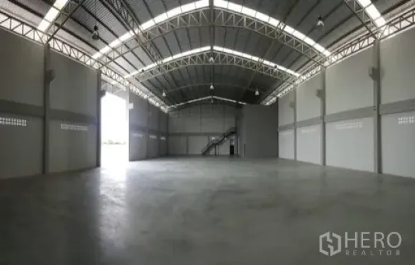 Factory for rent or sale in Bang Sao Thong, Samut Prakan - Spacious industrial space with steel truss roof and roller-door access.