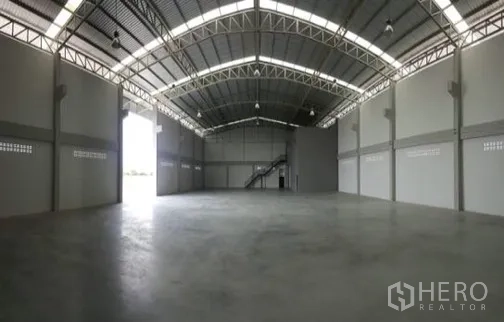 Factory for rent or sale in Bang Sao Thong, Samut Prakan - Spacious industrial space with steel truss roof and roller-door access.