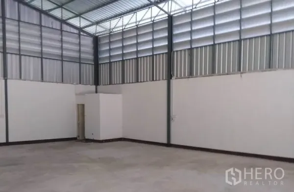 Warehouse for rent in Bang Yai, Nonthaburi - Open warehouse floor with high steel trusses, concrete slab and a corner restroom.