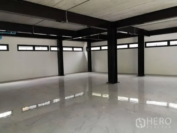 Office Space for rent in Chatuchak, Bangkok - Corner view of empty office with black metal beams, high strip windows and glossy marble‑look flooring.
