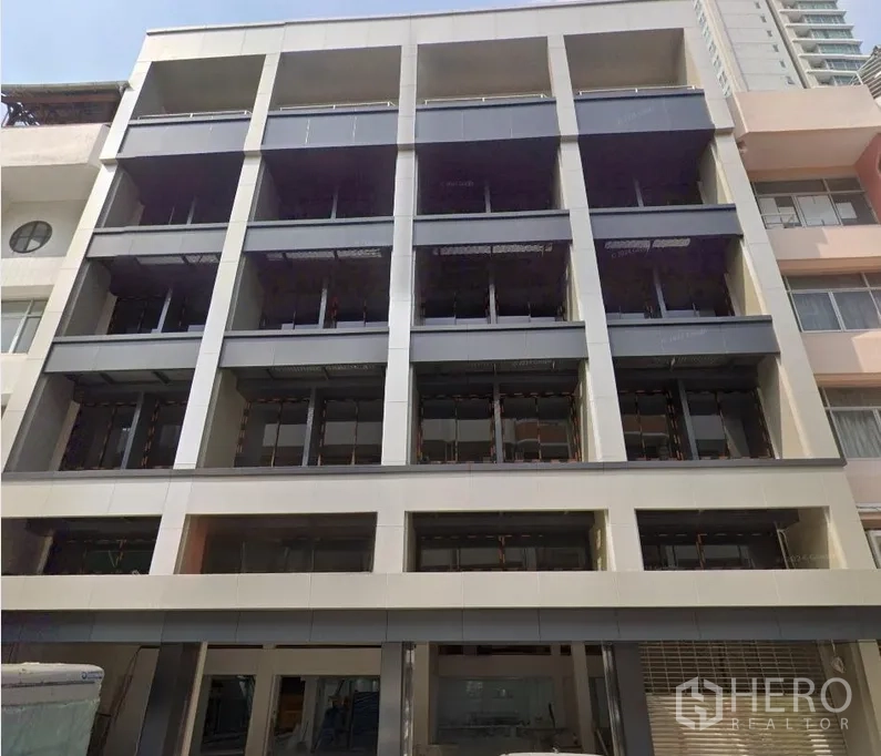 Office Space for rent or sale in Huai Khwang, Bangkok - Modern mid-rise office building facade with large grid-style openings and glass.