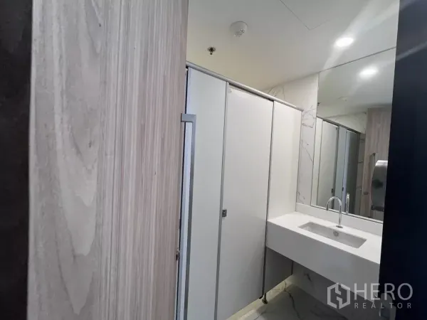 Office Space for rent in Din Daeng, Bangkok - Renovated restroom with white vanity, large mirror and partitioned stalls in a marble-accent finish.
