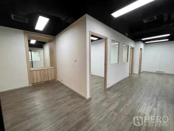 Office Space for rent in Khlong Toei, Bangkok - Interior showing partitioned rooms, reception nook and built-in cabinets on wood flooring.