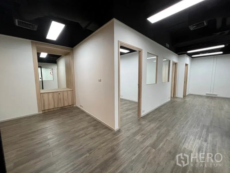 Office Space for rent in Khlong Toei, Bangkok - Interior showing partitioned rooms, reception nook and built-in cabinets on wood flooring.