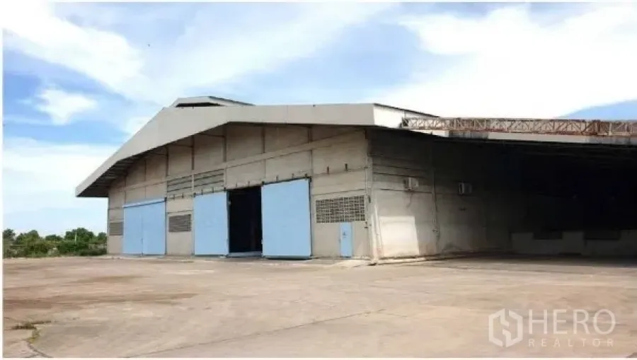 工厂 出租 - 厂房外立面，大型推拉门与宽阔混凝土堆场