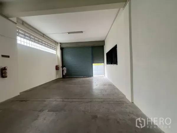 Warehouse for rent in Phra Khanong, Bangkok - Clean warehouse bay with high ceiling, strip lighting and large roller shutter door