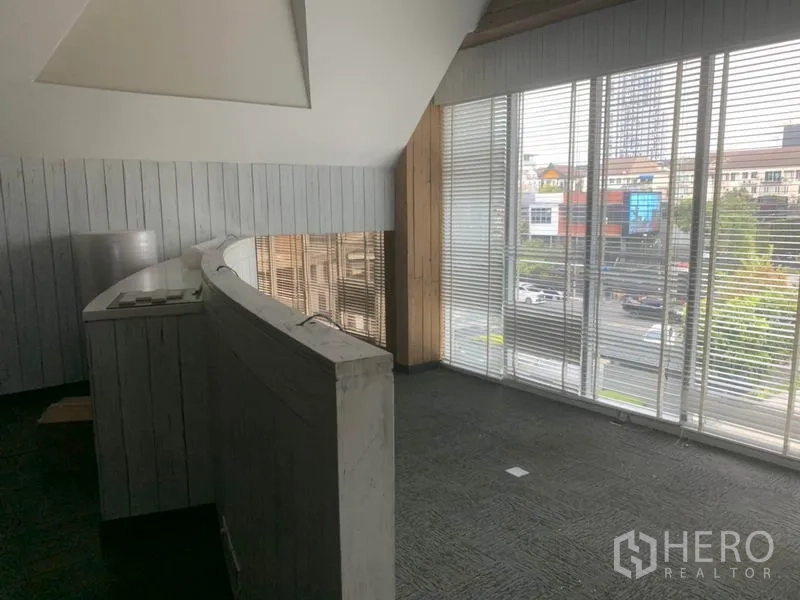 Retail Space for rent in Watthana, Bangkok - Corner mezzanine with full-height windows, city street view and whitewashed wall panels.