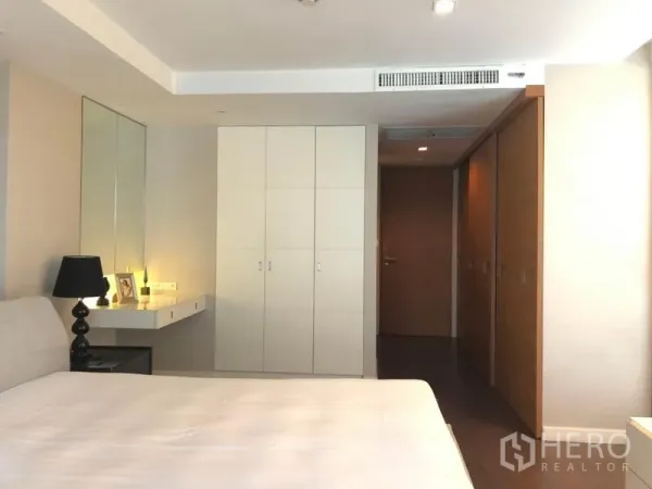 Condominium for rent in Pathum Wan, Bangkok - Bright bedroom with dressing table, white closets and recessed ceiling lights.