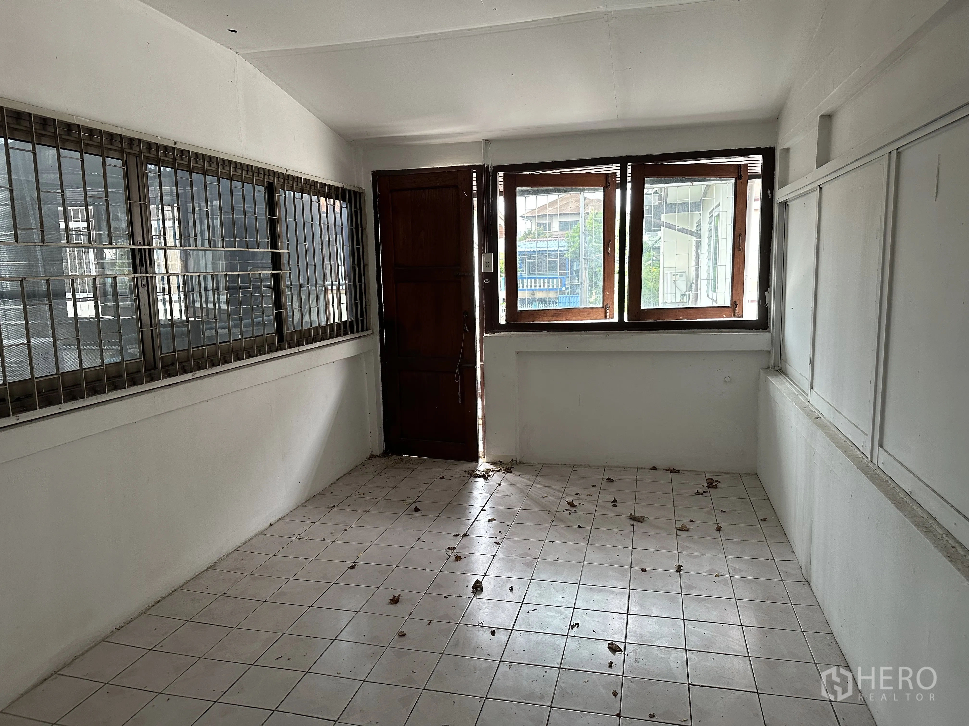 Home Office for rent in Suan Luang, Bangkok - Enclosed corridor-like room with metal-grilled windows and a wooden door.