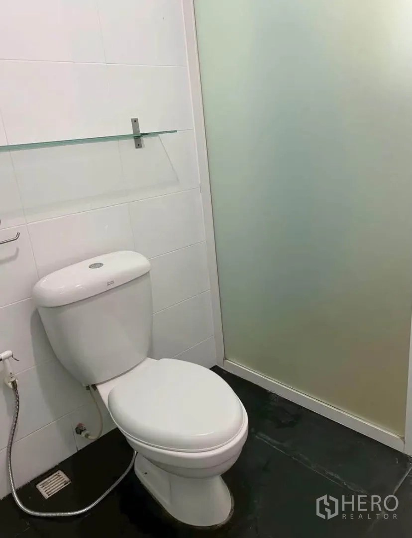 Townhouse for rent in Phra Khanong, Bangkok - Toilet room with frosted glass shower door and handheld bidet spray.