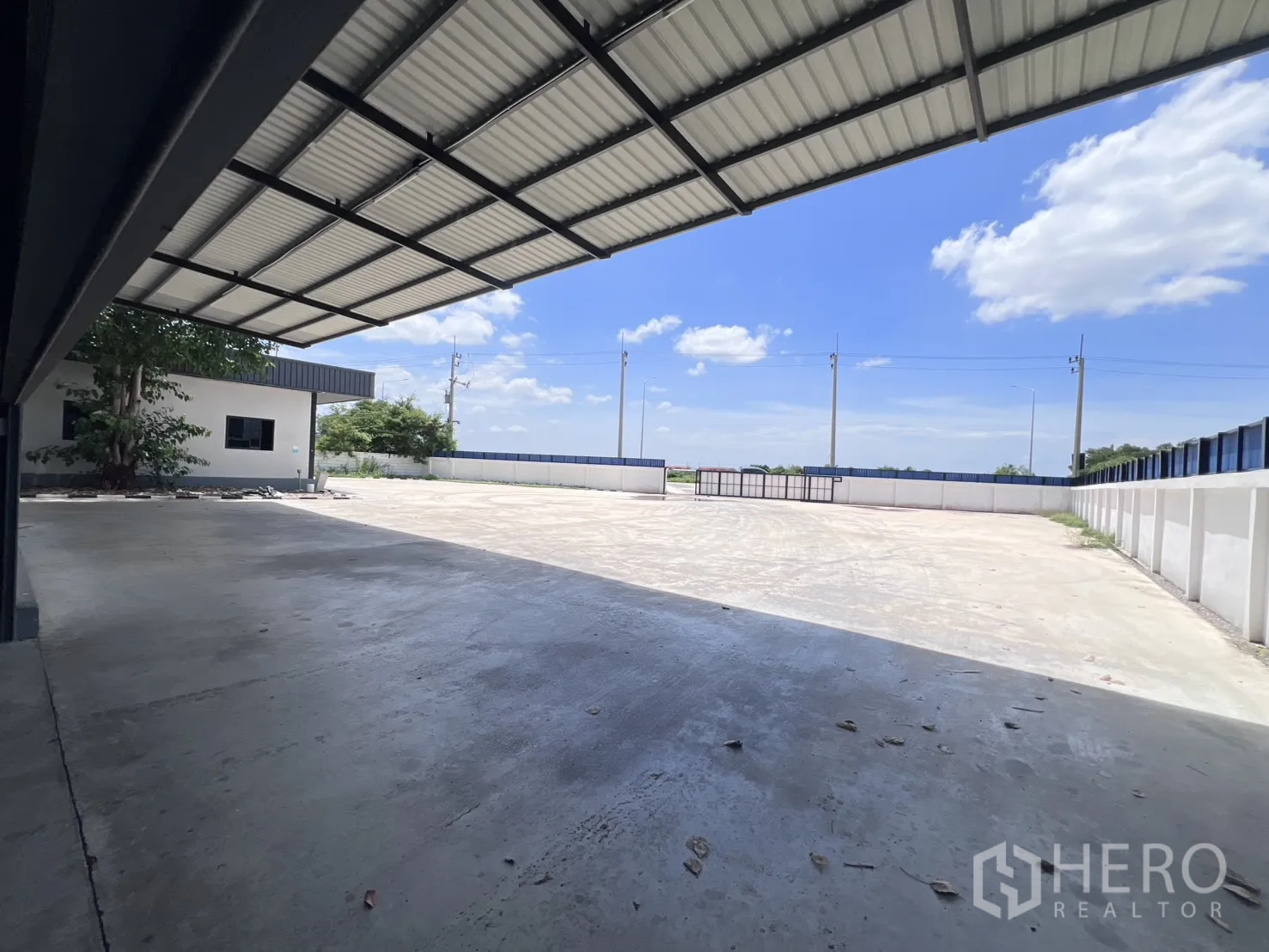 仓库 for rent in Mueang Samut Sakhon, Samut Sakhon - 带顶装卸月台，眺望铺装场地与园区大门。