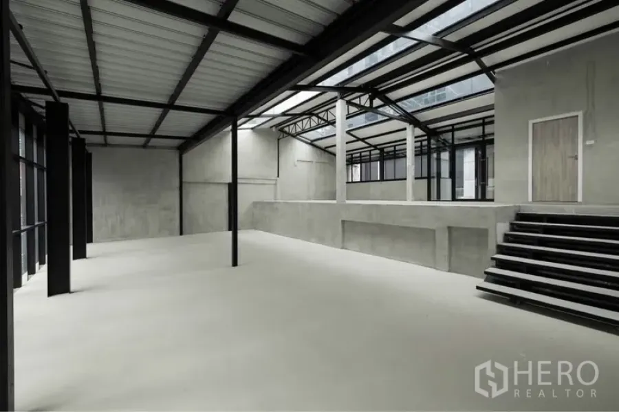 Retail Space for rent in Watthana, Bangkok - Industrial retail hall featuring a raised platform, wide stairs, exposed trusses, and skylight panels.