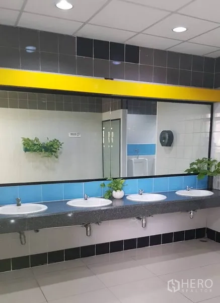 Office Space for rent in Huai Khwang, Bangkok - Long vanity with multiple sinks, large mirror and potted plants in a restroom