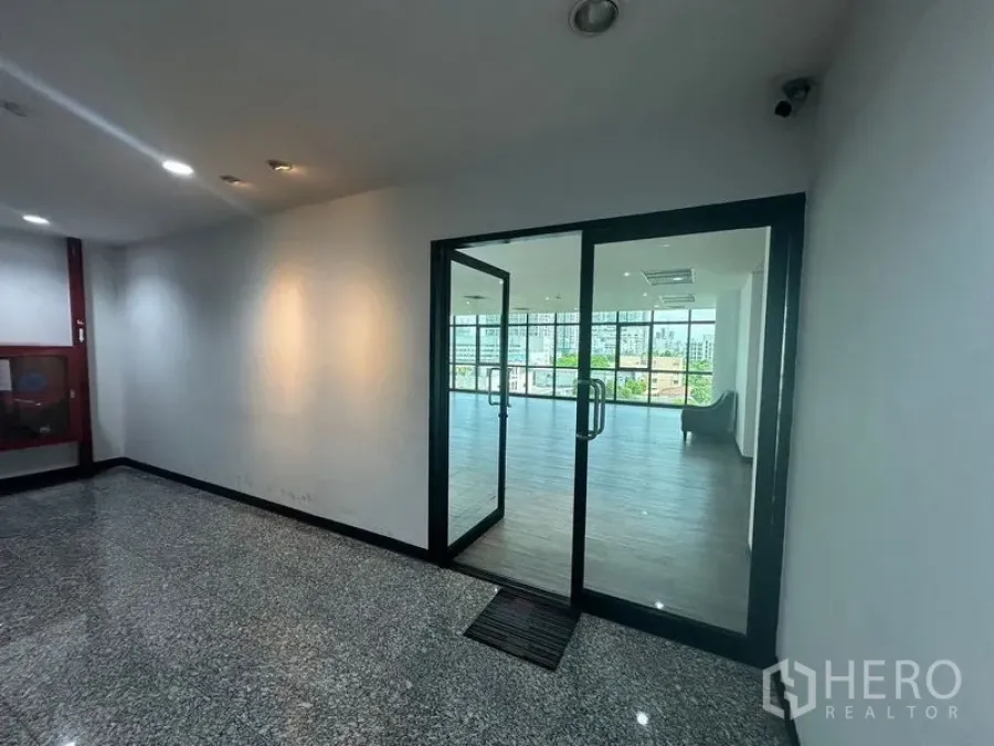 Office Space for rent in Khlong Toei, Bangkok - Entrance foyer with a glass door opening to a sunlit office and skyline views.