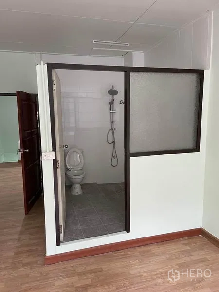 Shophouse for rent in Phaya Thai, Bangkok - Bathroom with glass partition, shower set and toilet.