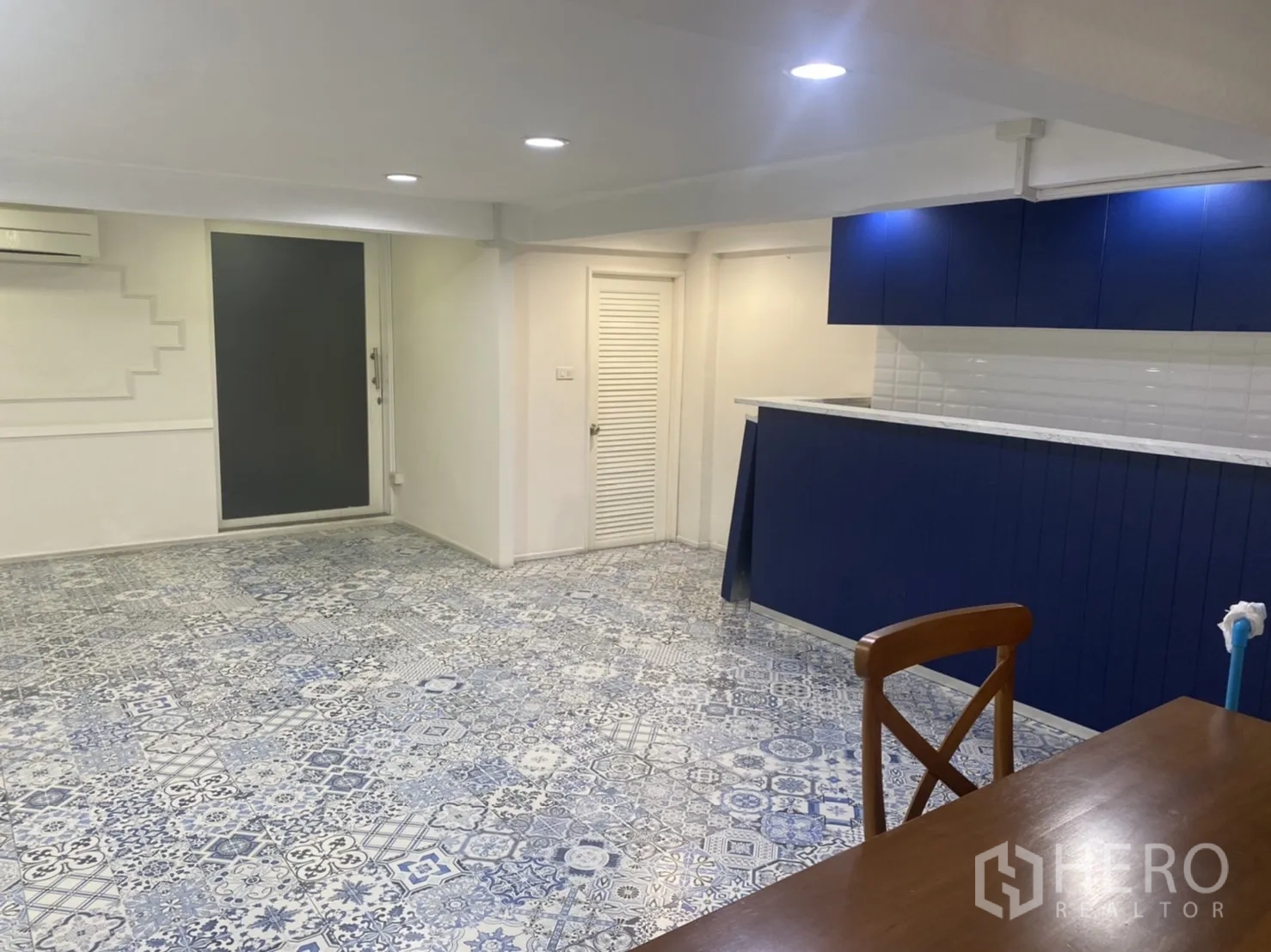 Retail Space for rent in Bang Rak, Bangkok - Navy bar counter with storage and recessed ceiling lights in a low-ceiling area of the shop.