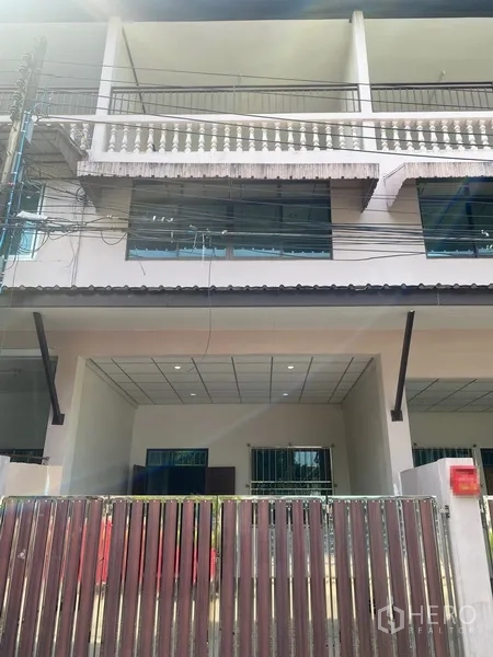 联排别墅 出租在Suan Luang, Bangkok - 三层联排别墅外立面，带大门车位、阳台与大窗，位于曼谷On Nut一带。