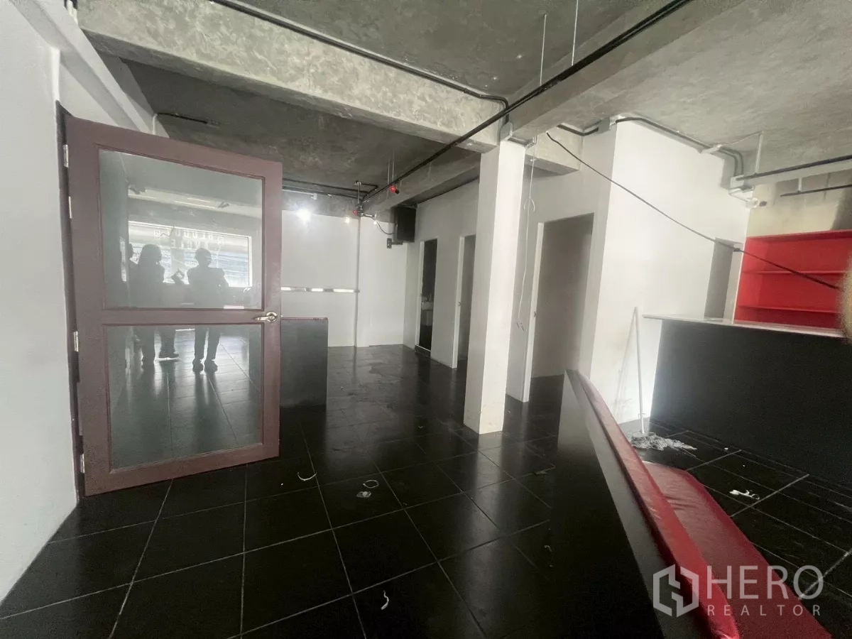 Shophouse for rent in Watthana, Bangkok - Open-plan floor with a glass entrance door and service counters.