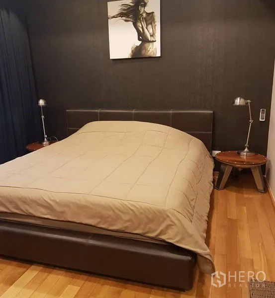 Condominium for rent or sale in Khlong Toei, Bangkok - Cozy bedroom with dark feature wall, king bed and bedside lamps.