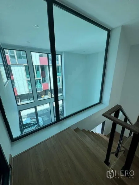 Townhouse for rent - Stair landing with large picture window overlooking neighboring townhomes.