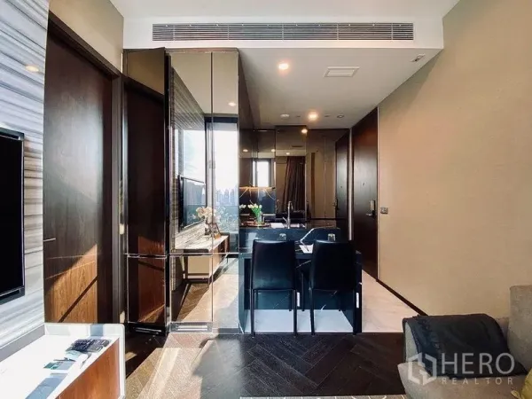 Condominium for rent in Khlong Toei, Bangkok - Open-plan living and dining area with mirror wall, four-seat dining set, and city light views.