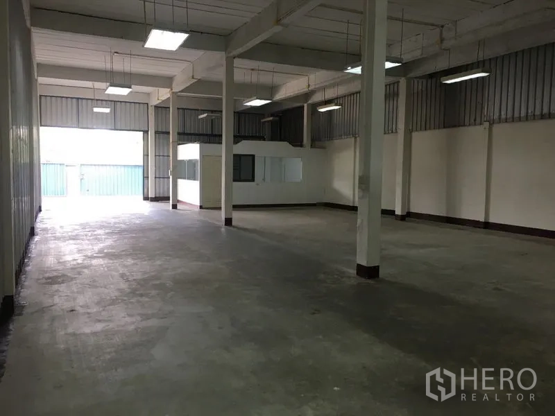 货栈 出租在Bueng Kum, Bangkok - 高挑层高的仓库内部，立柱与日光灯照明。
