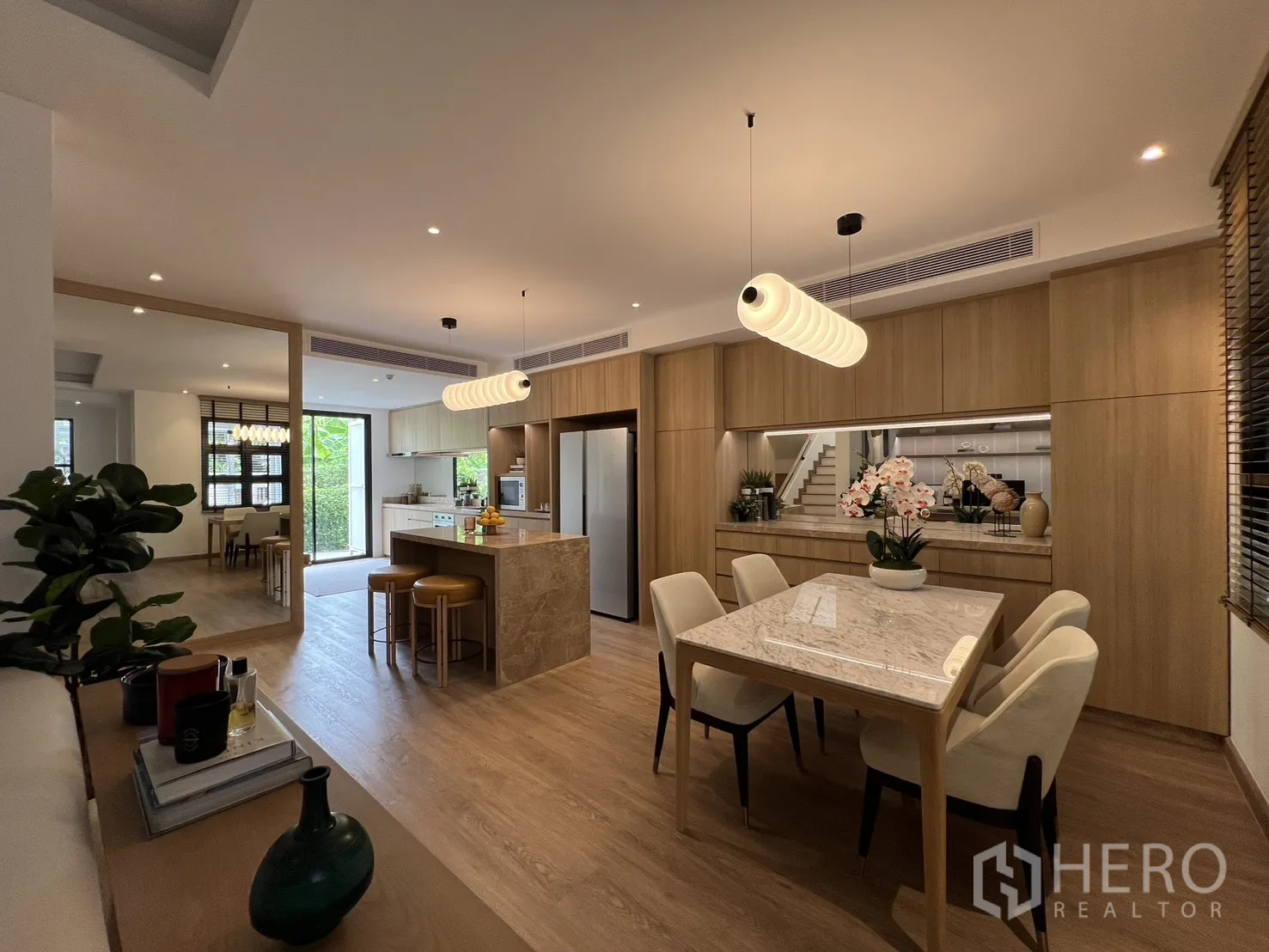 Townhouse for sale in Watthana, Bangkok - Dining area and lounge with floor-to-ceiling window and custom cabinetry.