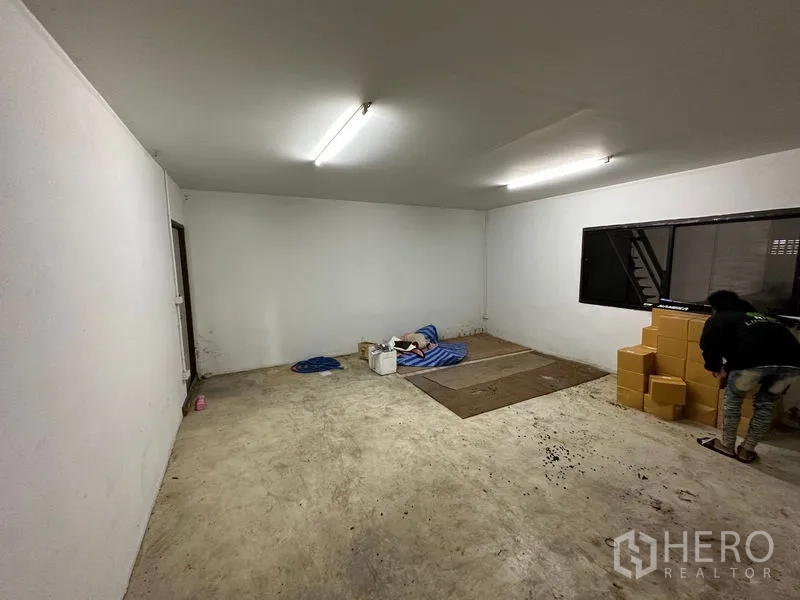 Warehouse for rent in Thanyaburi, Pathum Thani - Simple office room inside the warehouse with fluorescent lighting and a large window.