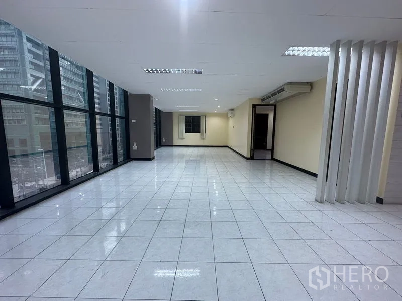 办公空间 出租在Bang Rak, Bangkok - 大面积工作区，整面落地玻璃外墙，城市景观。