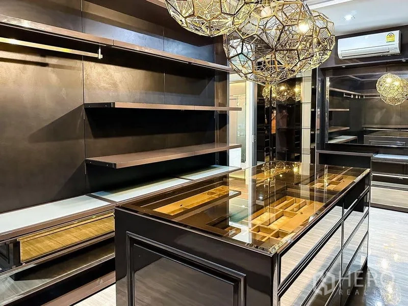 Condominium for rent or sale in Khlong Toei, Bangkok - Custom walk-in closet with display island, shelving and geometric pendant lights.
