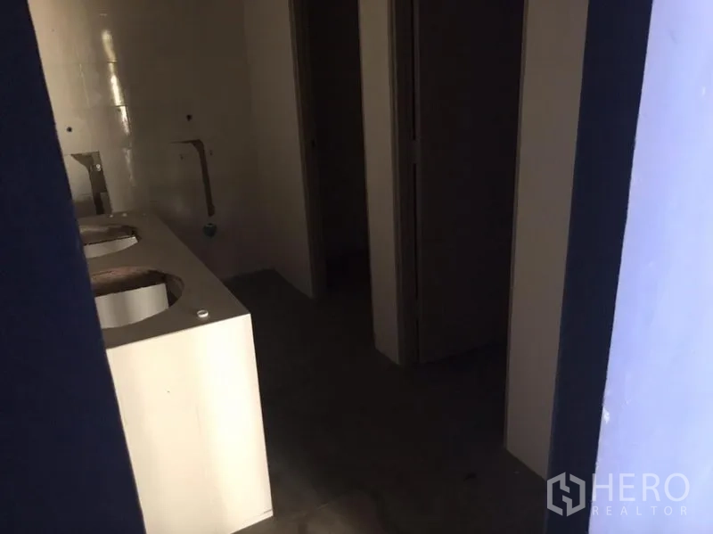 Shophouse for rent in Watthana, Bangkok - Restroom area featuring a twin sink counter and separate cubicles.