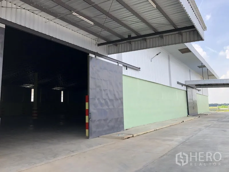 Warehouse for rent in Phra Nakhon Si Ayutthaya - Close-up of oversized sliding door beneath a deep loading canopy with ramp access to the warehouse.