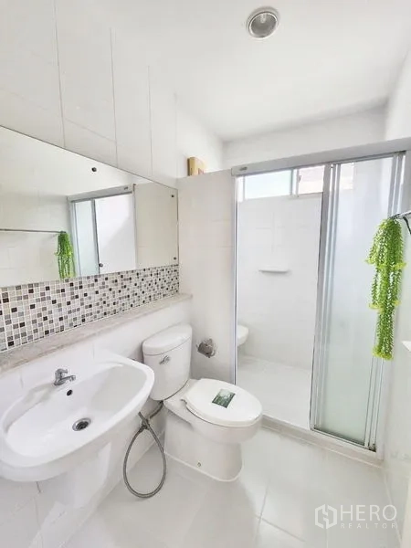 Detached House for rent in Prawet, Bangkok - Clean white bathroom with mosaic backsplash and glass shower enclosure.
