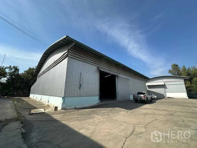 Warehouse for rent in Phra Nakhon Si Ayutthaya - Side angle of the warehouse building with concrete yard and loading access.