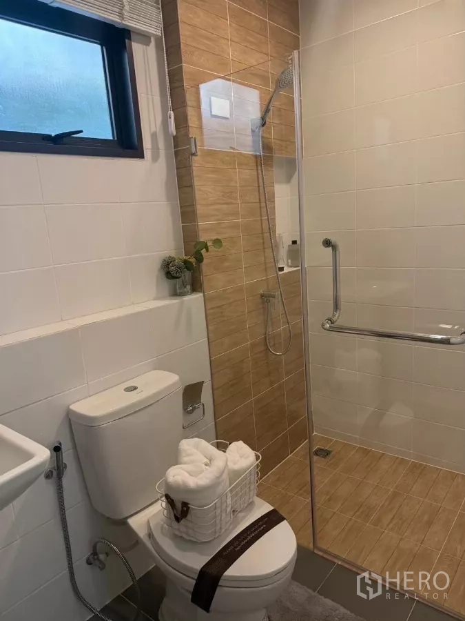 Townhouse for rent in Bang Phli, Samut Prakan - Clean bathroom with glass shower enclosure, rain shower and toilet.