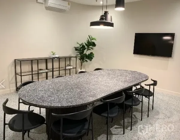 Office Space for rent in Khlong Toei, Bangkok - Modern boardroom featuring an oval terrazzo table, eight black chairs, pendant lights, wall-mounted TV and air conditioning.