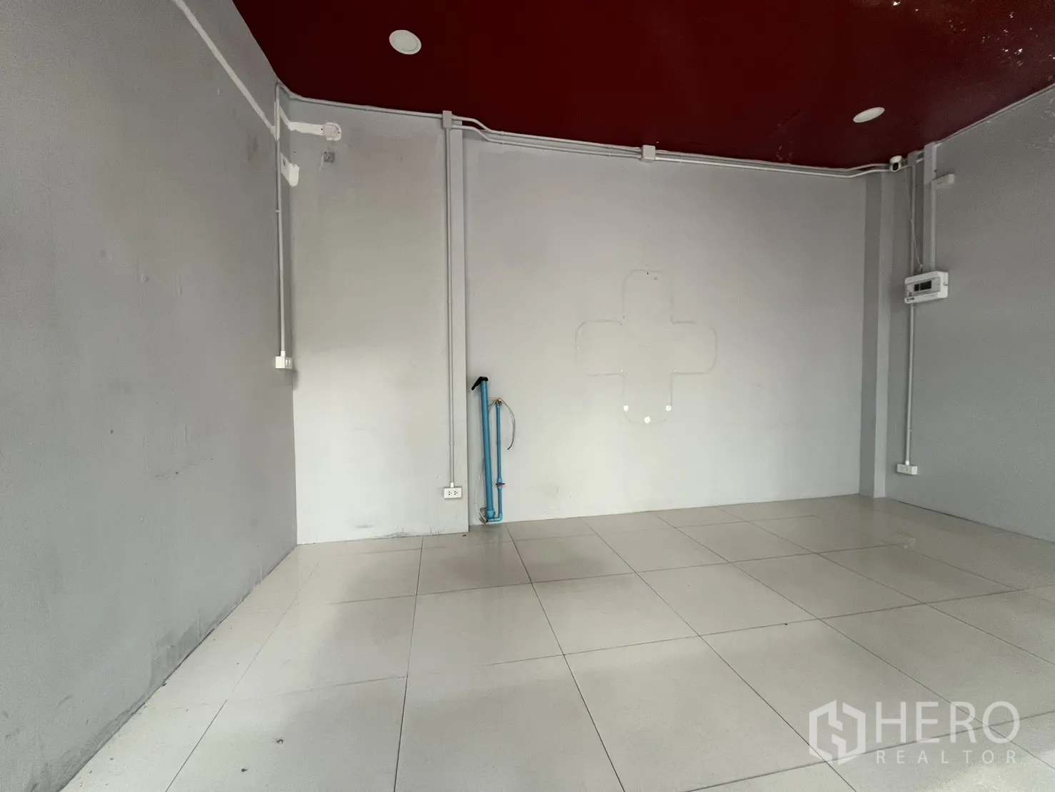 Retail Space for rent in Watthana, Bangkok - Empty tiled retail interior with exposed electrical conduit, maroon ceiling and utility point.