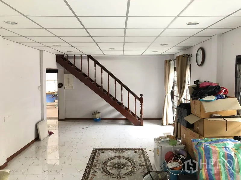 บ้าน ขายในPak Kret, Nonthaburi - พื้นที่รับแขกโล่งเชื่อมบันไดไม้ขึ้นชั้นสอง มีผ้าม่านและพื้นกระเบื้องเงา