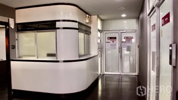 Office Space for rent in Suan Luang, Bangkok - Modern reception counter and glass-door corridor inside the office building