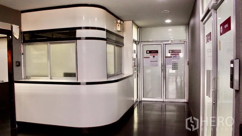 Office Space for rent in Suan Luang, Bangkok - Modern reception counter and glass-door corridor inside the office building