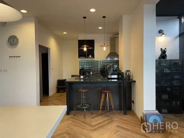 Detached House for sale in Sai Mai, Bangkok - Contemporary kitchen with black island, stools, tiled backsplash and pendant lighting.