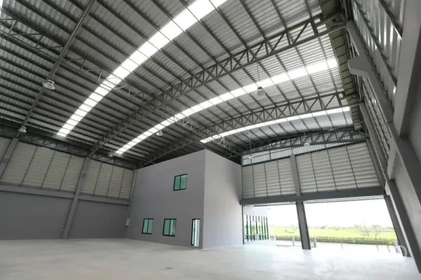 工厂 出租或出售在Bang Bo, Samut Prakan - 高挑仓库内部，拱形钢屋架、天窗与内置办公盒体。