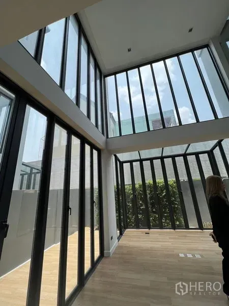Home Office for sale in Wang Thonglang, Bangkok - Bright ground-floor space featuring floor-to-ceiling glass walls opening to a private patio with greenery.