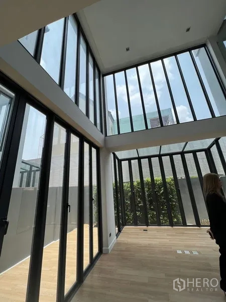 Home Office for sale in Wang Thonglang, Bangkok - Bright ground-floor space featuring floor-to-ceiling glass walls opening to a private patio with greenery.