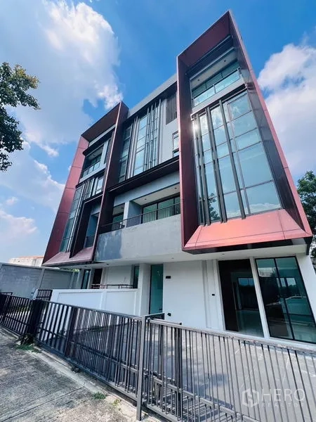 Home Office for sale in Bang Khen, Bangkok - Street view of a gated multi-storey home office with striking glass-and-metal facade in Bang Khen.