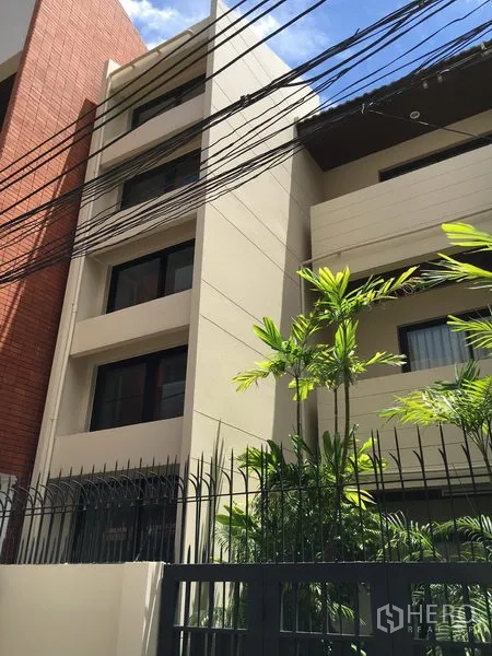 联排别墅 出租在Watthana, Bangkok - 现代多层联排别墅外立面，米色墙面、大窗与金属围栏。