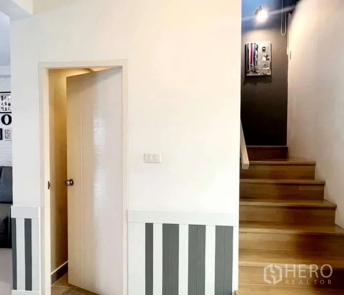 Detached House for rent in Bang Phli, Samut Prakan - Wood staircase beside a ground-floor powder room.