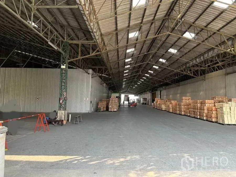 货栈 出租在Mueang Pathum Thani, Pathum Thani - 仓库内覆盖式装卸区，堆放纸箱，通道宽敞适合叉车与卡车通行。
