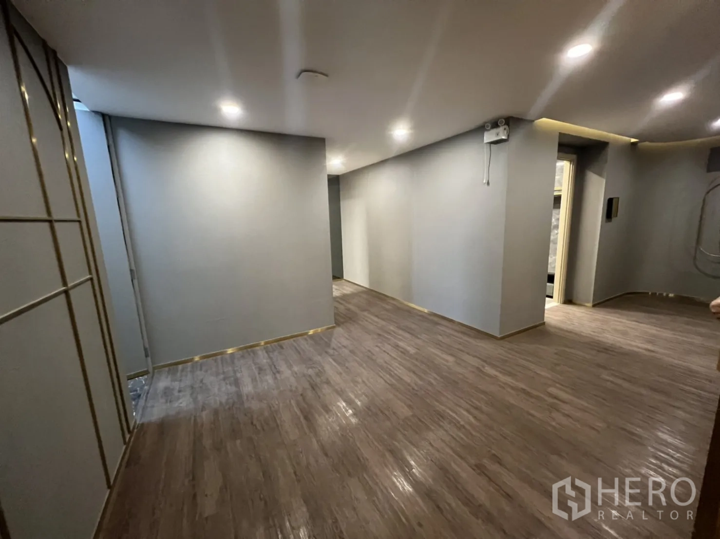 Shophouse for rent in Phra Khanong, Bangkok - Wide hallway with recessed lighting and resilient wood‑look floors.